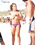 A lady enjoying the refreshing sea breeze in a natural, topless state.