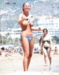 A lady enjoying the refreshing sea breeze in a natural, topless state.
