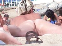 Nasses Haar und angezogene Knie am felsigen Nacktstrand
