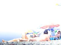 Two Nude Women Stroll a Quiet Pebble Beach