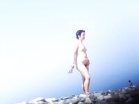 Two Nude Women Stroll a Quiet Pebble Beach