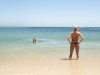 She Walks Through Shallow Water in Pink Bikini Bottoms