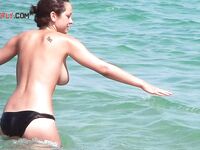 Tomar el sol topless con braguita negra bajo el sol estival