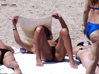 Topless et détendue en culotte colorée au soleil