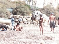 Nude Woman and Towel-Wrapped Man at a Nudist Beach
