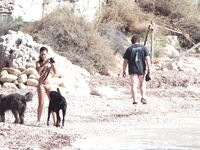 Nude Woman and Towel-Wrapped Man at a Nudist Beach
