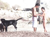 Nude Woman and Towel-Wrapped Man at a Nudist Beach