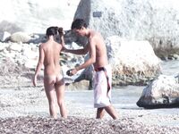 Nude Woman and Towel-Wrapped Man at a Nudist Beach