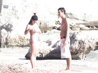 Nude Woman and Towel-Wrapped Man at a Nudist Beach