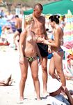 The natural light of the coast accentuating the beauty of a topless model on the beach.