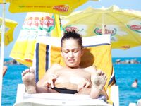 Toalha às riscas e sol topless descontraído na praia