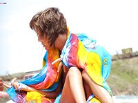 Toalha às riscas e sol topless descontraído na praia