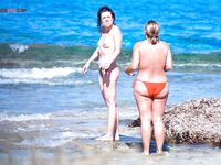 A lady enjoying the scenic coastal views in a relaxed, topless European style.