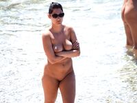 Sunlit Shoreline Nude Beach Pose with Dark Sunglasses