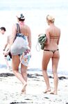 Sunlit Shoreline Nude Beach Pose with Dark Sunglasses
