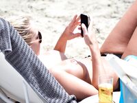 Sunlit Shoreline Nude Beach Pose with Dark Sunglasses