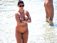 Sunlit Shoreline Nude Beach Pose with Dark Sunglasses