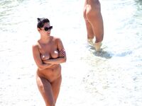 Sunlit Shoreline Nude Beach Pose with Dark Sunglasses