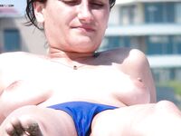 A lady enjoying the calm atmosphere of a secluded bay in a topless fashion.