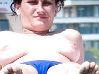 A lady enjoying the calm atmosphere of a secluded bay in a topless fashion.
