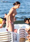 A lady enjoying the tranquility of the coast in a natural topless fashion.