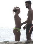 Laughing Topless Beach Sitter in Purple Bikini Bottoms
