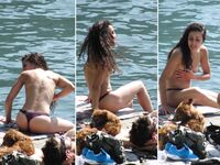 Laughing Topless Beach Sitter in Purple Bikini Bottoms