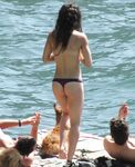 Laughing Topless Beach Sitter in Purple Bikini Bottoms