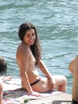 Laughing Topless Beach Sitter in Purple Bikini Bottoms