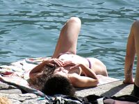 Laughing Topless Beach Sitter in Purple Bikini Bottoms