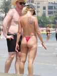 Laughing Topless Beach Sitter in Purple Bikini Bottoms