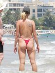Laughing Topless Beach Sitter in Purple Bikini Bottoms