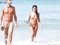 Two Nudists Strolling Along a Rocky Shoreline