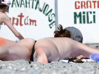 Here I am quietly posing for photos while being watched by a nude guy on the beach.