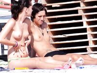 A woman enjoying the view of the waves in a relaxed topless state.