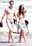 Topless op een druk zonnig strand tussen andere strandgangers