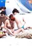 Na kolanach na ciepłym piasku przy brzegu cichej plaży nudystów
