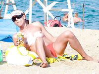 Na kolanach na ciepłym piasku przy brzegu cichej plaży nudystów
