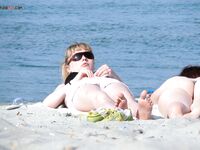 Relaxing on a private towel at a clothing-optional beach, feeling completely at ease.