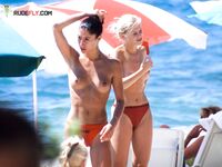 Dva nudisté v rozhovoru po kotníky v ústranné zátoce