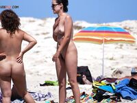 Dva nudisté v rozhovoru po kotníky v ústranné zátoce