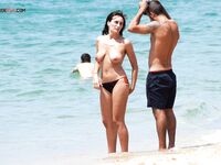 Dva nudisté v rozhovoru po kotníky v ústranné zátoce