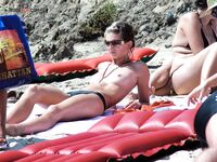 Basking in the soft evening light, enjoying the tranquility of a beautiful nude beach.