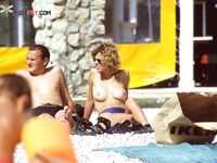 Applying Sunscreen on a Rocky Beach by the Sea