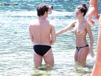 Shoreline Nudist Beach Stroll with Water Droplets on Skin