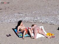 Een topless pose buiten met sieraden tegen een blauwe lucht