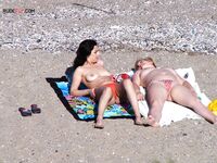 Een topless pose buiten met sieraden tegen een blauwe lucht