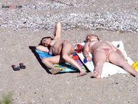 Een topless pose buiten met sieraden tegen een blauwe lucht