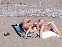 Een topless pose buiten met sieraden tegen een blauwe lucht