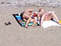 Een topless pose buiten met sieraden tegen een blauwe lucht